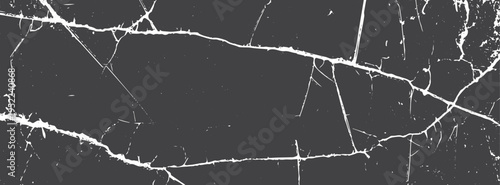 White jagged cracks on a dark grey stone surface texture