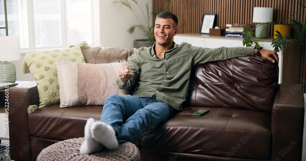 Obraz premium Smile, remote and man on sofa for watching tv, movie or series in living room for weekend. Relax, subscription and male person in home for streaming film, channel and television show in apartment
