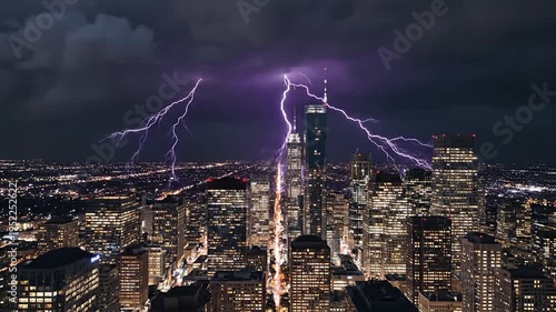 Lightning strikes a dense urban cityscape during a powerful storm