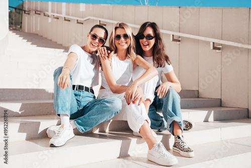Slika na platnu Three young beautiful smiling hipster female in trendy summer t-shirt  and jeans clothes