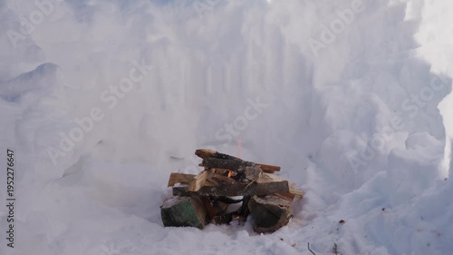 Wallpaper Mural Small campfire burning inside a deep snow pit in winter. Thin smoke rises above the stacked firewood while flames slowly burn in the cold snowy environment. High quality 4k footage Torontodigital.ca