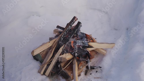 Wallpaper Mural Small campfire made of stacked firewood burning inside a snow pit in winter. Flames appear between wooden logs while the fire burns outdoors in cold snowy conditions. High quality 4k footage Torontodigital.ca