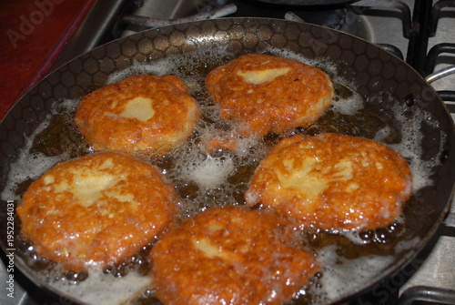 Egg fritters frying in pan with oil