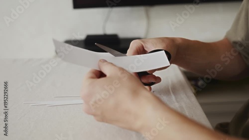 Wallpaper Mural Hands cutting paper with scissors during a simple home craft activity. Camera stays steady, highlighting everyday manual work and focus. High quality 4k footage Torontodigital.ca