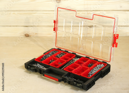 Organizer with many different fasteners and wrenches on wooden table, flat lay.