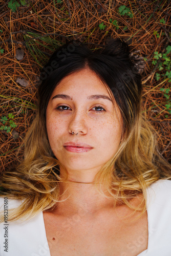 portrait of a young Latino brunette girl using Jeans and a blue shirt in a country setting with a lot of green and trees in the background