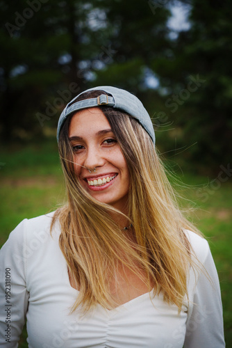 portrait of a young Latino brunette girl using Jeans and a blue shirt in a country setting with a lot of green and trees in the background