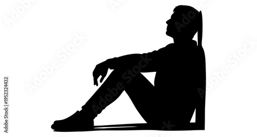 Silhouette of a person sitting against a wall looking up