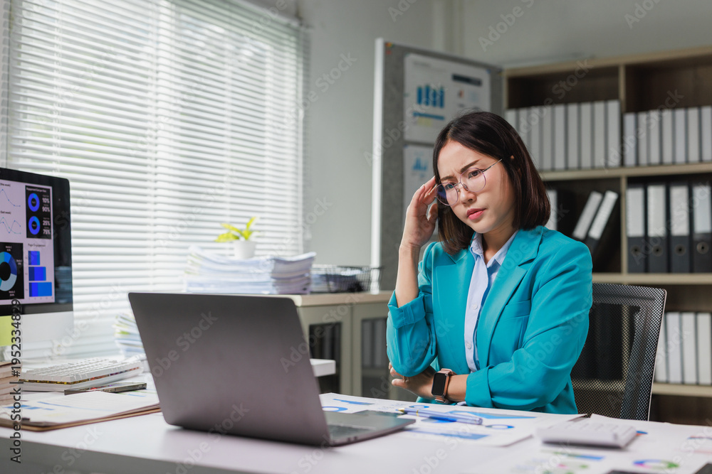 Obraz premium Stressed businesswoman suffering headache working in office