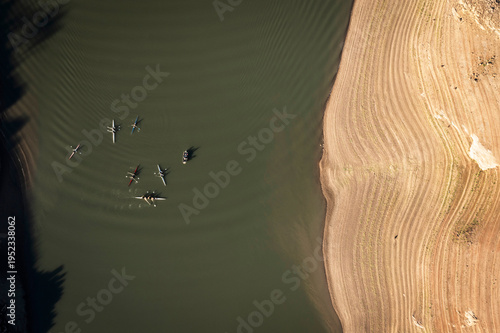 Aerial stright-down view of kayakers in a nearly dry reservoir.