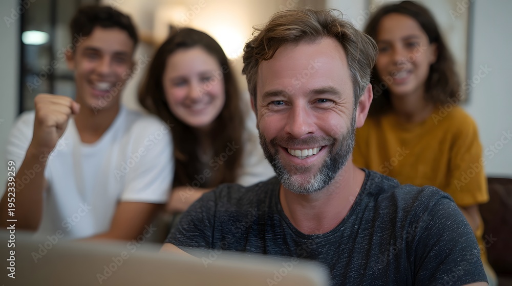 Obraz premium Smiling man and three joyful young people enthusiastically watch a laptop screen indoors sharing a moment of excitement and connection