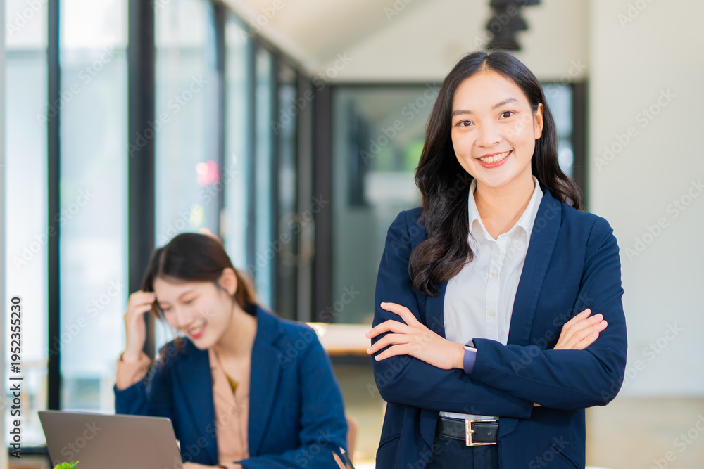 Obraz premium Smiling and elegant Asian businesswoman in business suit and office work.