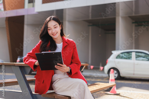Young asian woman planning business while reviewing documents outside