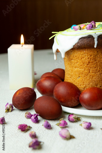 Candle, Easter cake with eggs on a plate is on the table