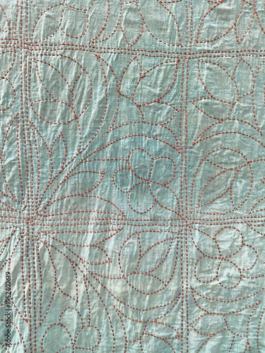 Red Hand-Stitched Floral Pattern on Light Blue Embroidered Fabric