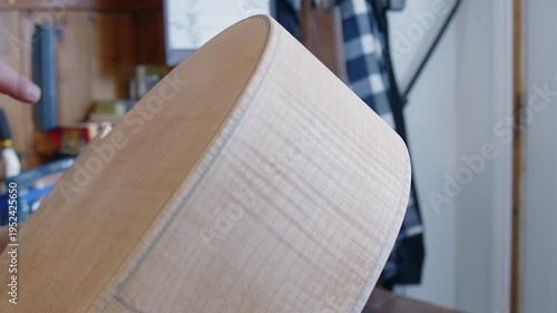 Closeup detail: Luthier works on acoustic guitar body in his shop