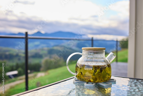 Fotografía A glass teapot filled with herbal tea sits on a table