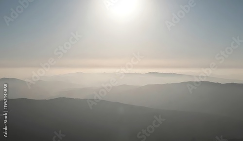 Hazy Sun Over Mountain Landscape
