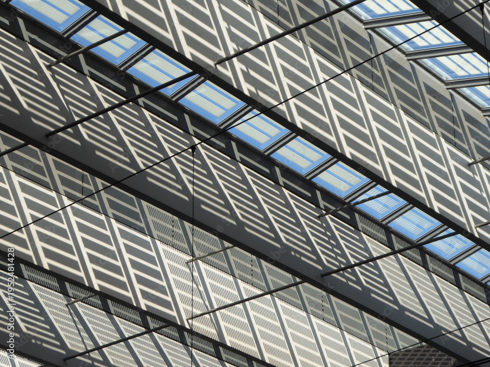 Obraz premium Abstract view of a glass roof supported by a steel structure, highlighting geometric patterns, transparency, and modern architectural design.