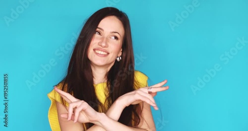 Cheerful young brunette woman dancing and laughing isolated on blue background, happy female brunette enjoying music and having fun, positive lifestyle and vibrant energy concept