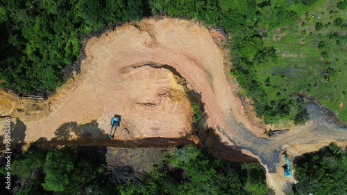 Foto Aerial top-down view showing excavators clearing a large patch of tropical forest to build a winding dirt road