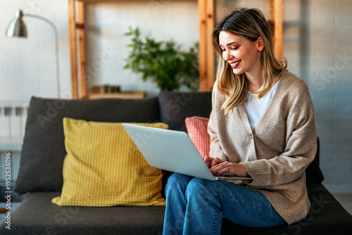 Woman working on laptop online, checking emails and planning on the internet at home office