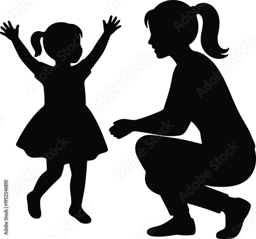 Silhouette of a happy young mother crouching and playing with her little daughter who is dancing with arms raised up