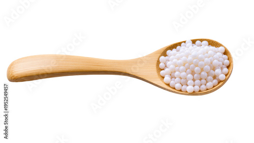Photos Isolated wooden spoon filled with numerous small white round homeopathic sugar pills