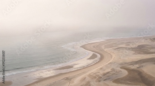 Ethereal fine art aerial photograph of a misty coastline where sand dunes meet the ocean