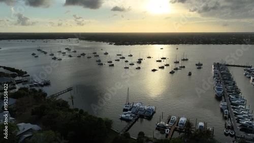 A high-altitude aerial shot reveals the peaceful marina landscape of Stuart’s Sunset Bay Marina glowing under warm golden hour light.