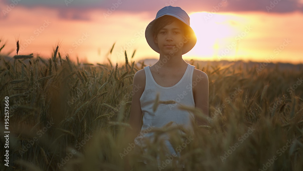 Fototapeta premium Boy Standing in Wheat Field at Sunset Wearing White Tank Top, have fun and enjoy