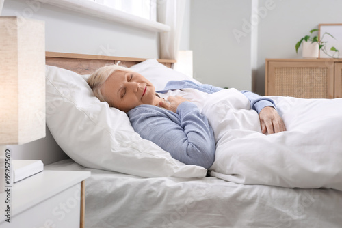 Senior woman sleeping in be...