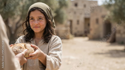 Young girl in ancient attire holding a loaf of bread. Biblical scene in a historical village. Sharing food and charity concept. Middle Eastern child in traditional headscarf and tunic