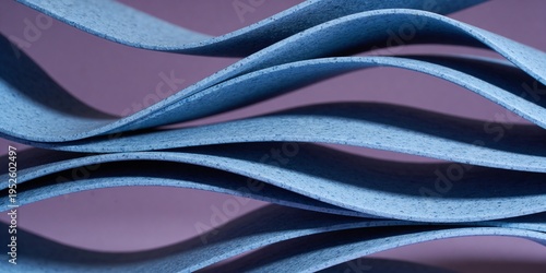 Waves of blue paper stacked against a pink background showing texture and patterns during a creative project