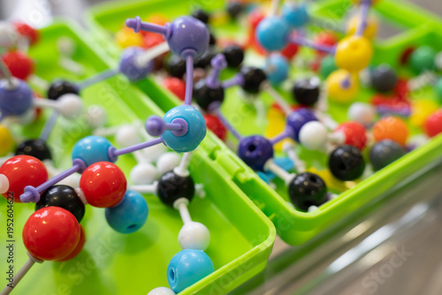 Colorful molecular model kits in green plastic boxes, science education concept.