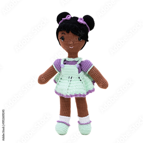 Afro plush doll with a lilac and green dress, made using the amigurumi crochet technique. Transparent background.