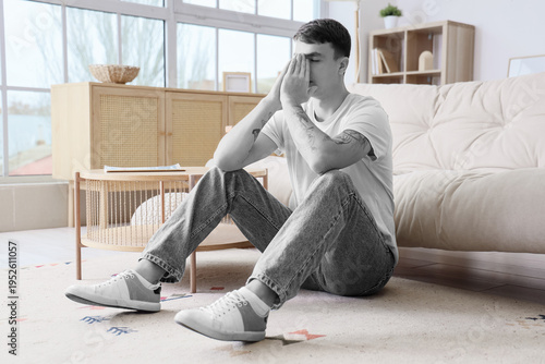 Worried young man sitting o...
