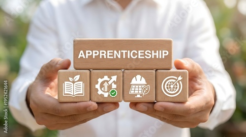 Hands holding wooden blocks with apprenticeship word and education skill development icons