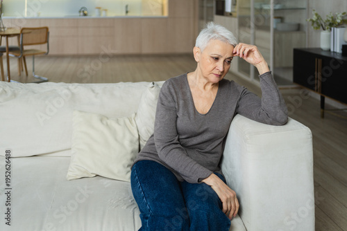 Sad tired ill sick lonely disappointed older senior woman sitting at home alone. Unhappy mature grandmother experiencing grief relative death bad news. Stressed elder lady suffering from loneliness