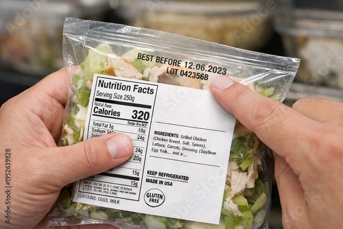 Close-up of hands inspecting food packaging with nutrition facts label and best before date in grocery store. concept of food safety, nutritional information, consumer awareness