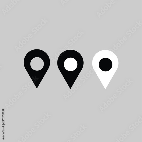 Three location pin icons two black one white on a gray background