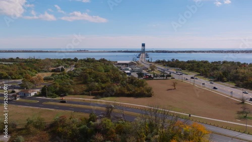 Aerial view of coastal lighthouse and roadway near shoreline, ProRes 422HQ footage
