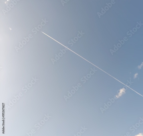 Konstfotografi A clear contrail cutting straight across the blue sky