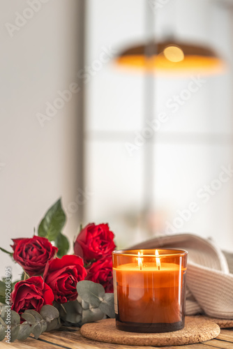 Vertical scene with candle roses and soft light. Cozy copyspace.