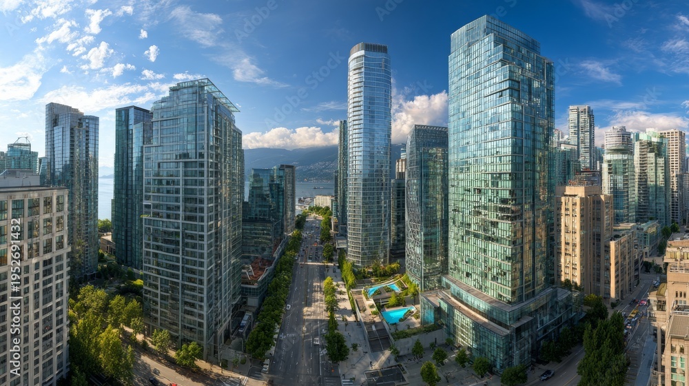 Fototapeta premium An urban panorama depicts high-rise buildings along a wide street, overlooking a body of water under a sunny sky