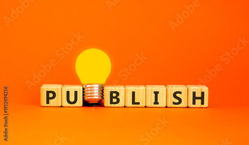 Publish word symbol. Concept word Publish on beautiful wooden blocks. Beautiful orange background. Beautiful yellow light bulb. Business publish word concept. Copy space.