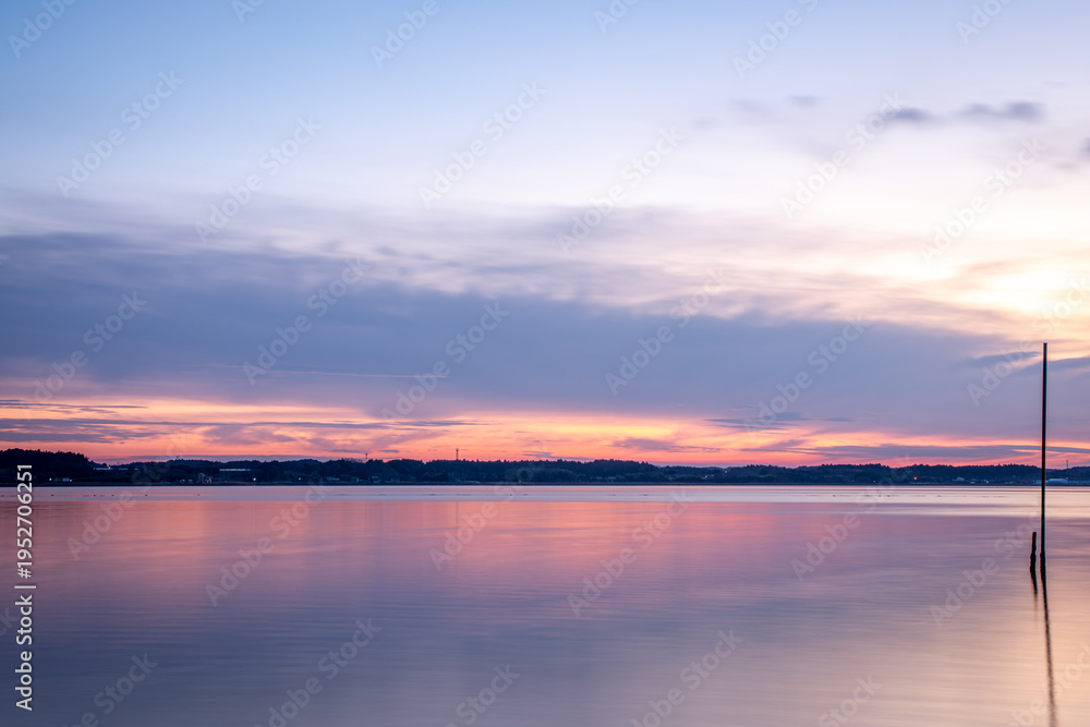 Obraz premium 涸沼湖に広がる夕暮れの彩りと静かな湖面の風景