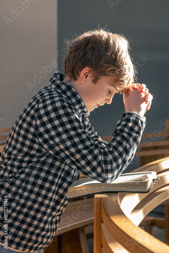 Fotografía Warm sunlight frames a childs prayer with an open Bible