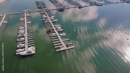 Aerial drone view of a large marina with rows of docked boats and piers over calm water, showing organized waterfront layout and coastal setting.