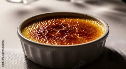 Golden Caramelized Crème Brûlée Dessert in White Ramekin on Table Ready to Be Served
